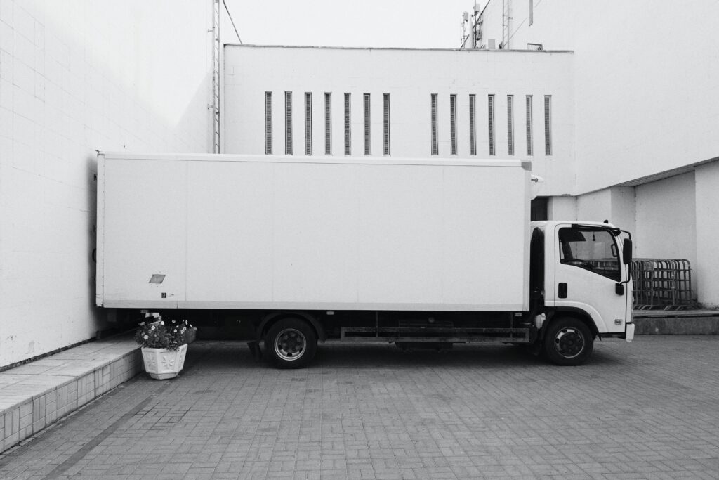 Office furniture moves - a white moving truck standing against a white building.